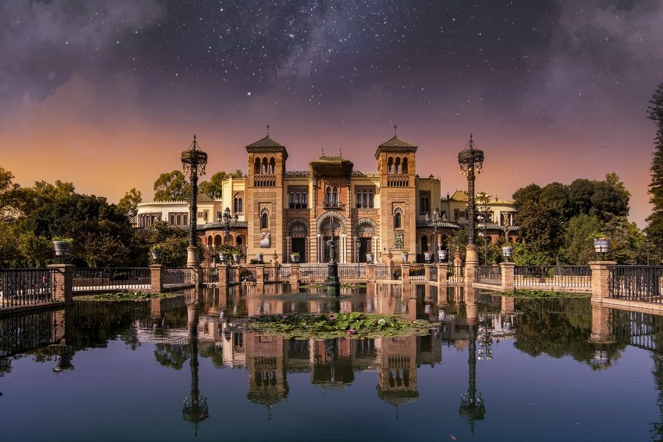 Seville&rsquo;s Plaza de Am&eacute;rica glowing under a night sky